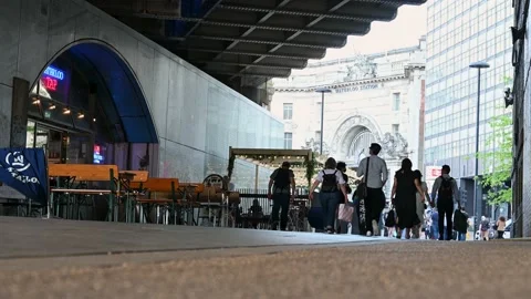 A low angle view of people walking along an path under a railway bridge with Stock Footage 159235251