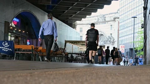 A low angle view of people walking along an path under a railway bridge with  Stock Footage 168457298