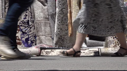 Low angle view of people walking past colorful carpets at market in Tunisia Stock Footage 328633550