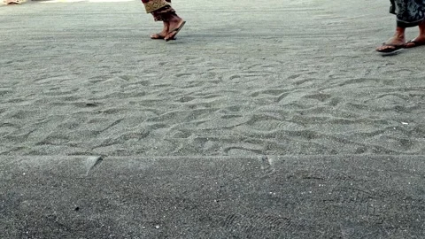 Low Angle View of People Walking Across Sandy Beach Ground in Sandals Stockbeeldmateriaal 341956325