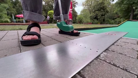 Low Angle View of Person Putting Yellow Ball on Outdoor Mini Golf Course Stock Footage 345520089