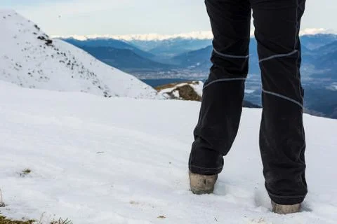 Low angle view of person walking on snow covered mountain ridge. Stock Photos