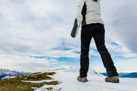 Low angle view of person walking on snow covered mountain ridge. Stock Photos