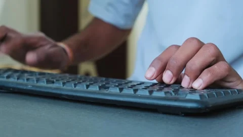 Low angle view of person's hands typing on keyboard in an office setting 스톡 동영상 329369653