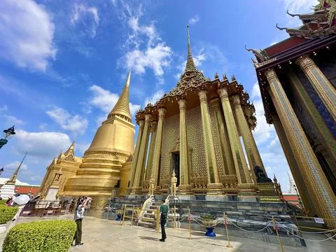 Low angle view of Phra Mondop and the golden Chedi stupa under a blue sky Stock Photos
