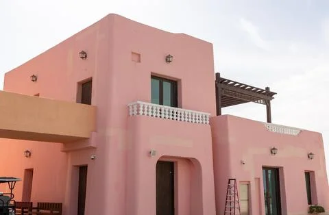 Low angle view of pink mediterranean building with pergola at Mina District. Stock Photos
