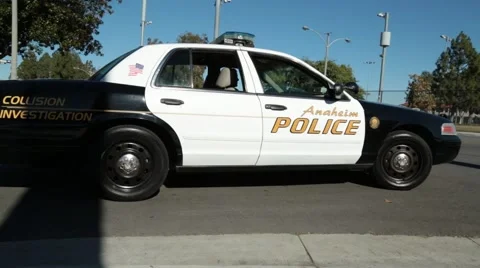 Low Angle View of Police Car Driving by a Street Corner Video stock 59165519