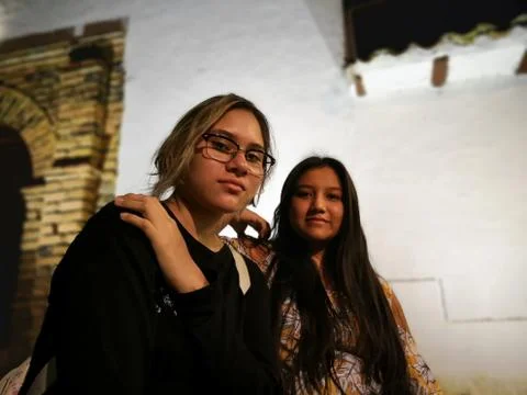 Low angle view portrait of two girls with Hispanic ethnicity at night Stock Photos
