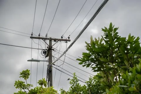 Low Angle View of Power Lines and Utility Pole against Overcast Sky Stock Photos