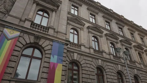 Low angle view of a Progress Pride rainbow flag banner and a colorful graphic Stock Footage 346239576