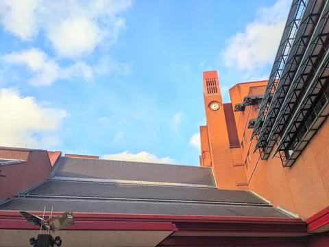Low angle view of the prominent red brick clock tower of the British Library Stock Photos