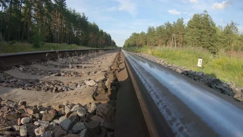 A low Angle View of Railroad Tracks with Forest and Grass in Background 4k60fps Stock Footage 135636581