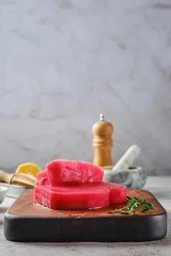 Low angle view of raw tuna steak on cutting board with spice Foto stock