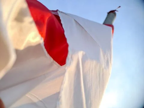 Low Angle View of a Red and White Flag Billowing in the Wind Stock Photos