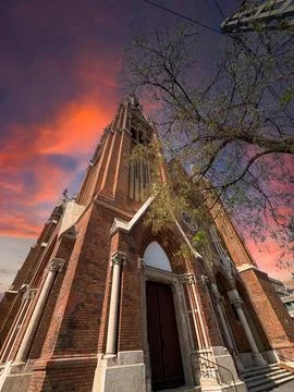 Low angle view of red brick church with tall tower Foto stock