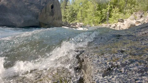 Low angle view of river water rushing over rock. Water splashes camera. Stock Footage 167985965