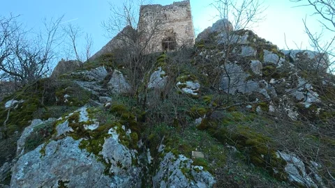 Low-Angle View From Rocks to Medieval Tower – Pan Right to Hills, Sunny Autumn Video stock 330958823