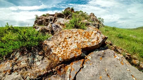 Low Angle View of Rocky Outcrop in Grassy Landscape Stock Footage 308280892