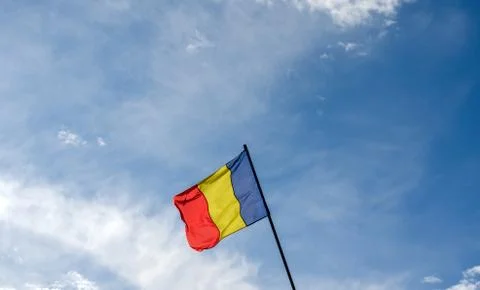 Low angle view of Romania flag  agains cloudy  blue sky. Stock Photos
