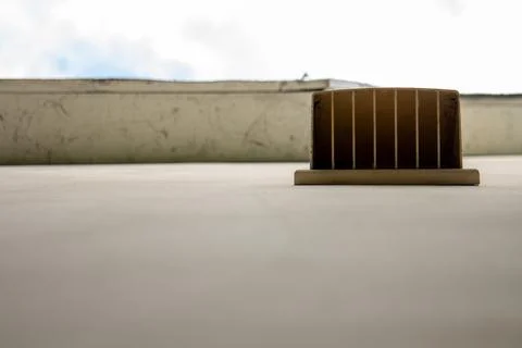 Low angle view of a rooftop vent hood on a commercial building roof surface 库存照片