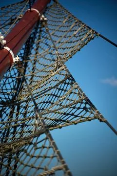 Low angle view of rope netting and wooden mast rigging against blue sky, Gdyn 스톡 사진