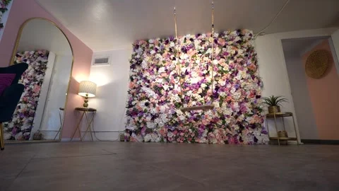 Low angle view of a rope swing hanging before a rose flower wall Stock Footage 345558118