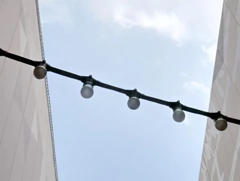 Low Angle View of A Row of Light Bulbs with Electrical Cable Foto stock