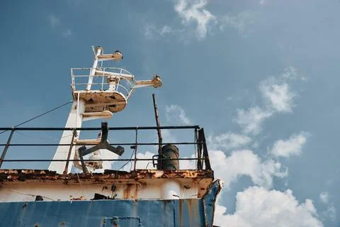 Low angle view of rusty ship mast and navigation equipment against cloudy b.. Stock-Fotos