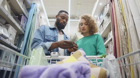 Low angle view of sad young couple with shopping cart having little money to pay Video stock 136315785