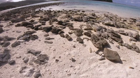 Low angle view of sandy rocky beach of Koromiri look out to horizon and an islet Stock Footage 250402074