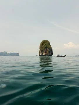 Low angle view of sea stack with long-tail boats and jellyfish Stock Photos