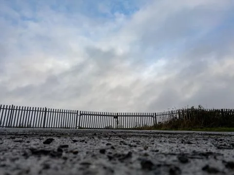 A low angle view of a section of metal fence surrounding an industrial estate Foto stock