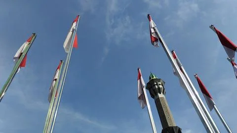 A low angle view of several tall flagpoles with red and white flags, combin.. Stock Photos