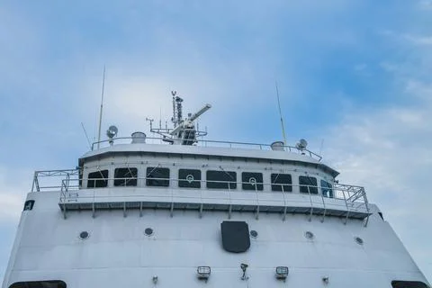 Low angle view of a ship navigation bridge tower with radar against a blue sk Stock Photos