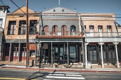 Low angle view of shops in old buildings in city with blue sky in background Stock Photos