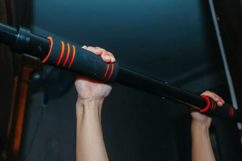 A low-angle view showing a person holding a pull-up bar with foam grips to .. Stock Photos