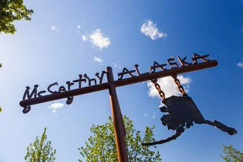 Low angle view of a sign for McCarthy, Alaska against a blue sky Foto stock