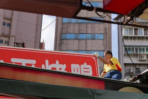 Low Angle View of Sign Worker Replacing Shop Sign in Taipei Stock-Fotos