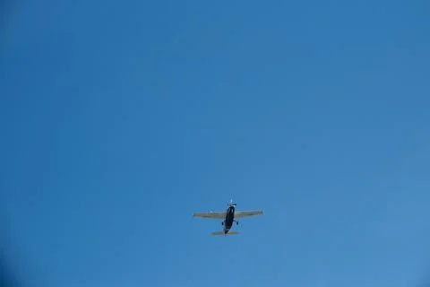 Low Angle View of a Single-Propeller Plane Flying in Clear Blue Sky Stock Photos
