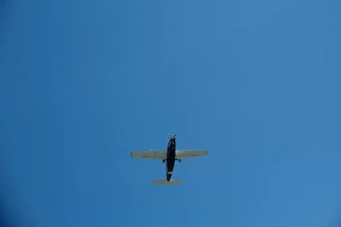 Low Angle View of a Single-Propeller Plane Flying in Clear Blue Sky Stock Photos