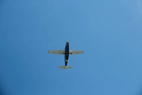 Low Angle View of a Single-Propeller Plane Flying in Clear Blue Sky Stock Photos