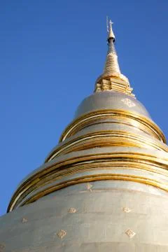Low angle view of a single white and golden pagoda with blue sky in Bangkok Stock Photos