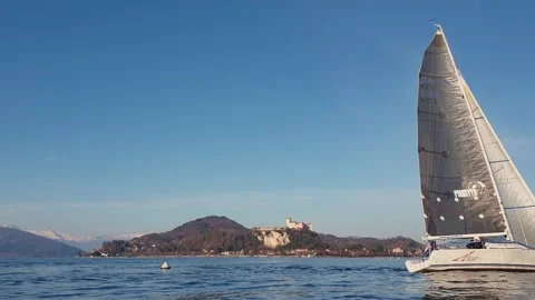 Low-angle view of small sailboat sailing on tranquil waters of maggiore lake Stock Footage 280888937