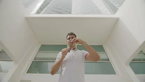 Low angle view of of smart, intelligent student in modern, whitish interior Stock Footage 235771862