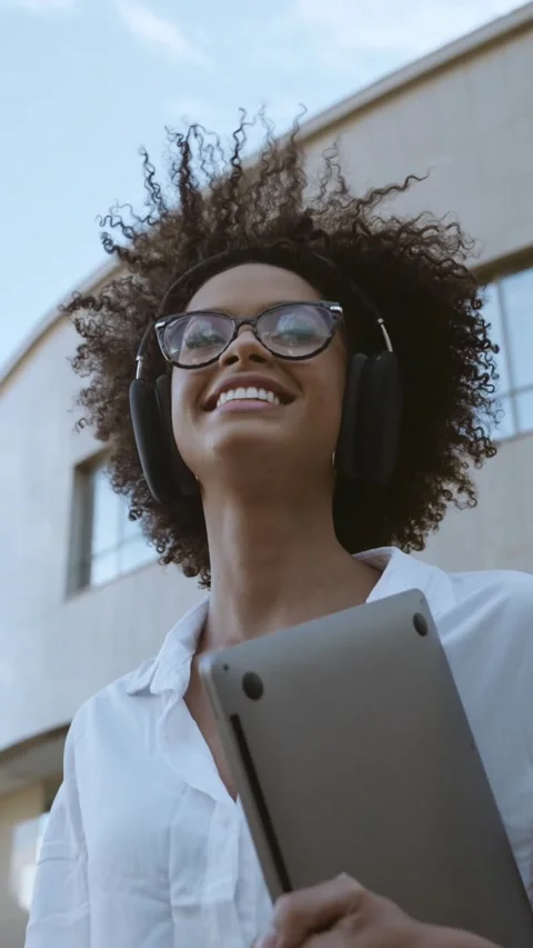 Low angle view of smiling Latin businesswoman holding laptop and eyeglasses n Stock Footage 219647065