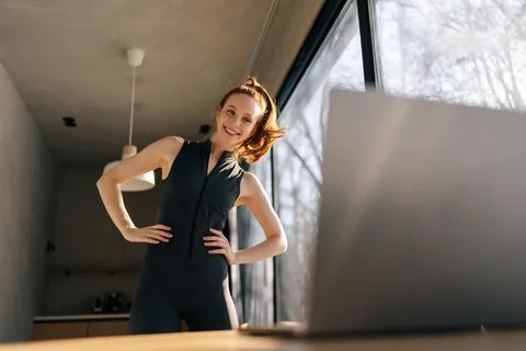 Low-angle view of smiling young woman working out, doing warming up exercise Stock Photos