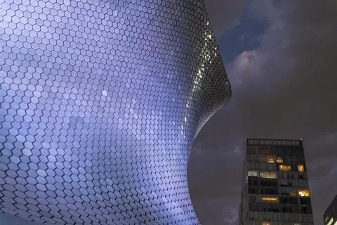 Low-angle view of Soumaya Museum under dark cloudy sky Foto stock