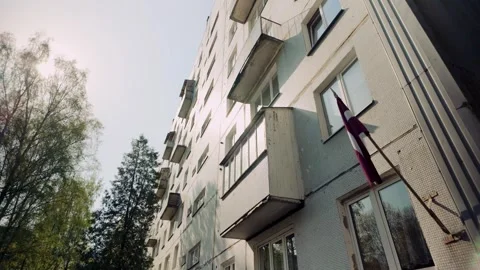 Low angle view on Soviet ex USSR apartment block with Latvian flag in Stock Footage 274538122