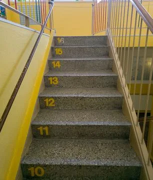 Low angle view of stairs with numbered steps in a modern bright yellow building. Fotos de archivo