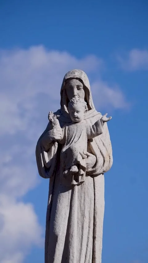 Low angle view statue of Virgin Mary with Jesus against blue sky Stock Footage 314502325